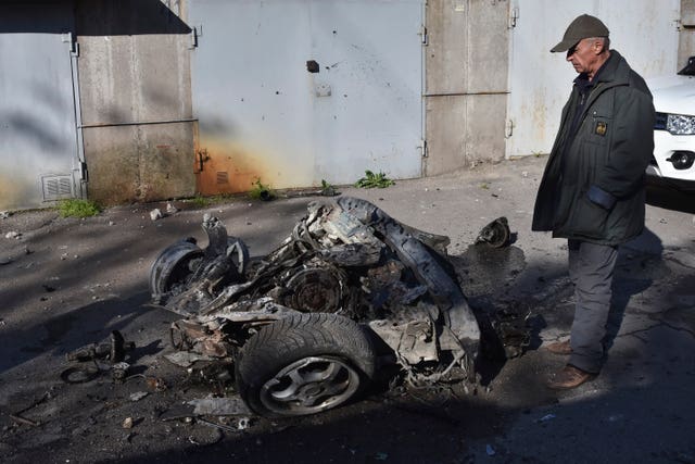 A man looks at the debris of a car following a Russian missile attack in Zaporizhzhia, Ukraine 