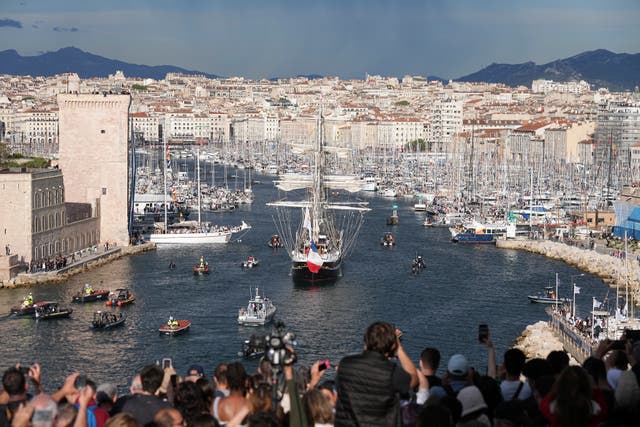 Crowds watch as the Belem, the three-masted sailing ship bringing the Olympic flame from Greece, enters the Old Port in Marseille, southern France