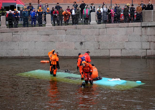Emergency responders work to recover victims of a bus crash in St Petersburg, Russia