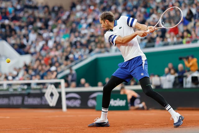 Russia’s Daniil Medvedev, wearing leg protection because of the cold, plays a shot against Tomas Machac