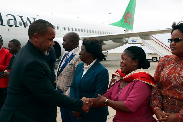 Saulos Chilima greets government officials at an airport