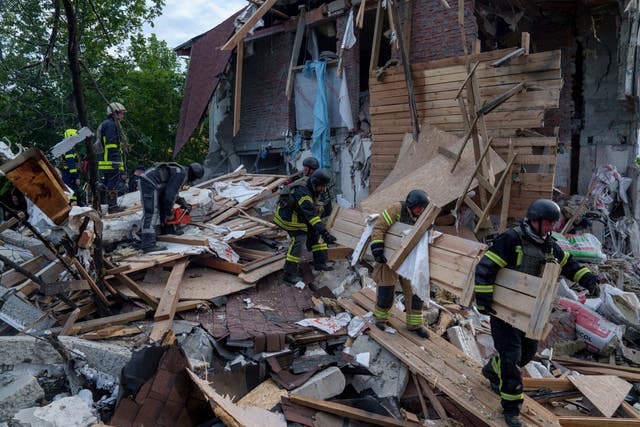Rescue workers clear the rubble of a building which was destroyed by a Russian airstrike in Kharkiv