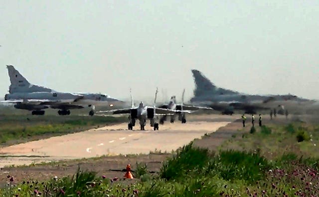 A pair of MiG-31 fighter jets taxi out for a training mission with two Tu-22M3 bombers seen in the background during joint Russian-Belarusian drills 