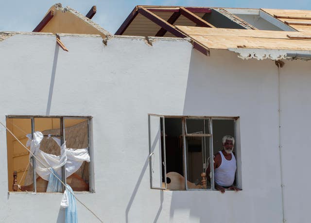A man looks out of the window of his home, which was destroyed by Hurricane Beryl in Clifton, Union Island, St Vincent and the Grenadines
