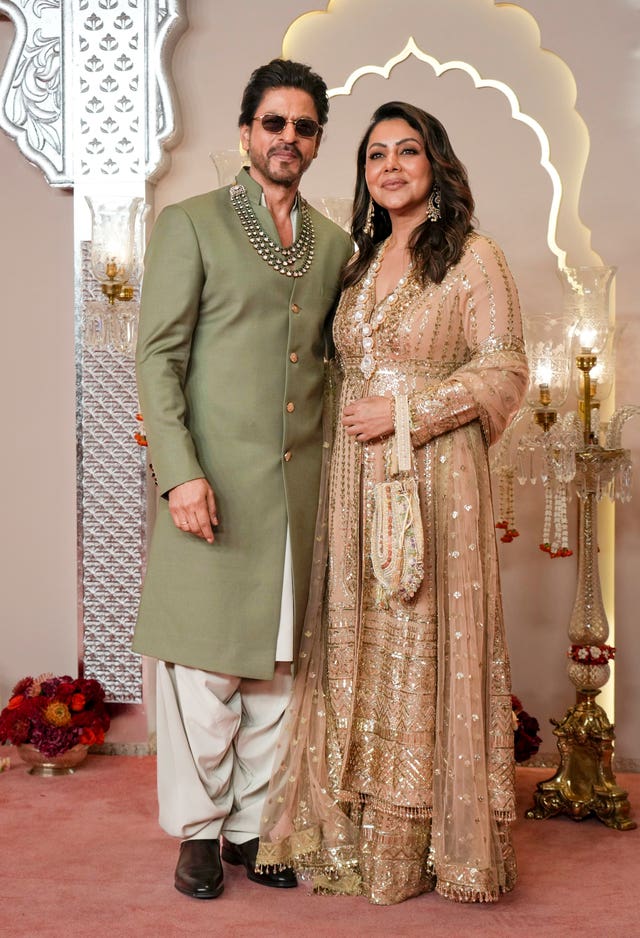 Bollywood actor Shah Rukh Khan in a green suits with his wife Gauri in beige