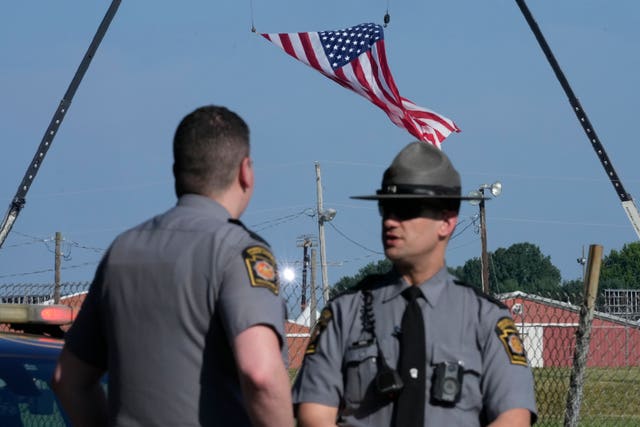 Police officers stand at a road leading to the site of the Trump rally in Butler, Pennsylvania