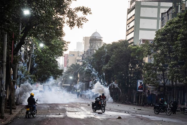 Police officers fire tear gas during a protest in Nairobi