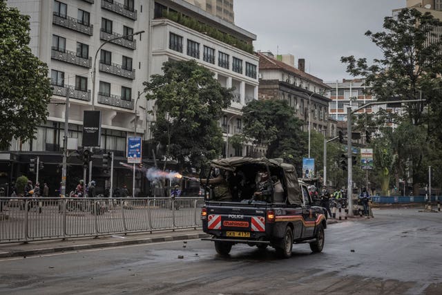 Police fire tear gas from the back of a vehicle in Nairobi