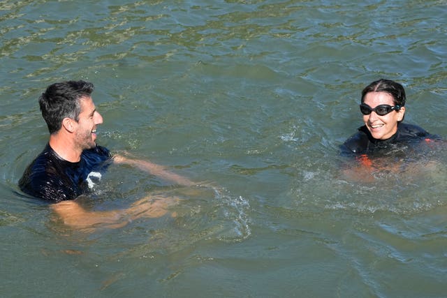 Paris Mayor Anne Hidalgo, right, and Tony Estanguet, president of Paris 2024, smiling and swimming in the Seine earlier this month