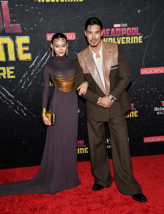 Lewis Tan and Lucy Qiu pose arm in arm on red carpet
