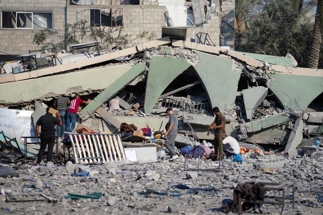 Palestinians inspect the rubble of a school