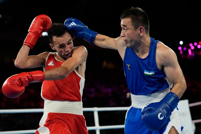 Uzbek Hasanboy Dusmatov, right, throws a punch