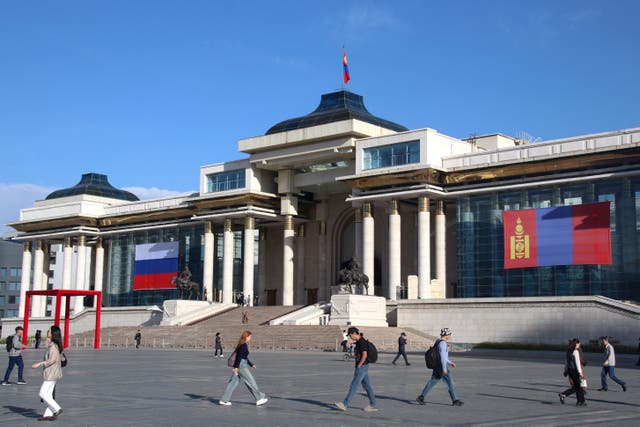 Exterior view of a large white building with the flags of Mongolia and Russia