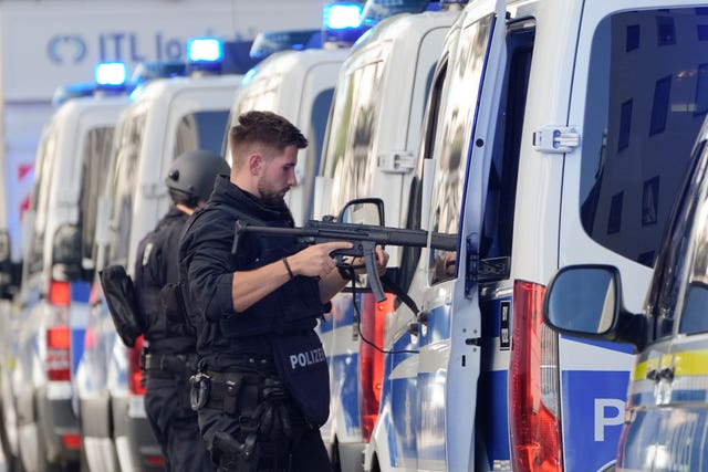 Police officers stand next to their vehicles after the incident in Munich