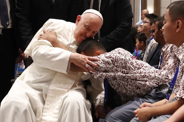 Pope Francis blesses a beneficiary from charitable organisations at the Indonesian Bishops’ Conference Headquarters in Jakarta