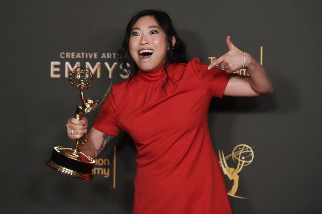 Awkwafina poses with the award for outstanding television movie for Quiz Lady