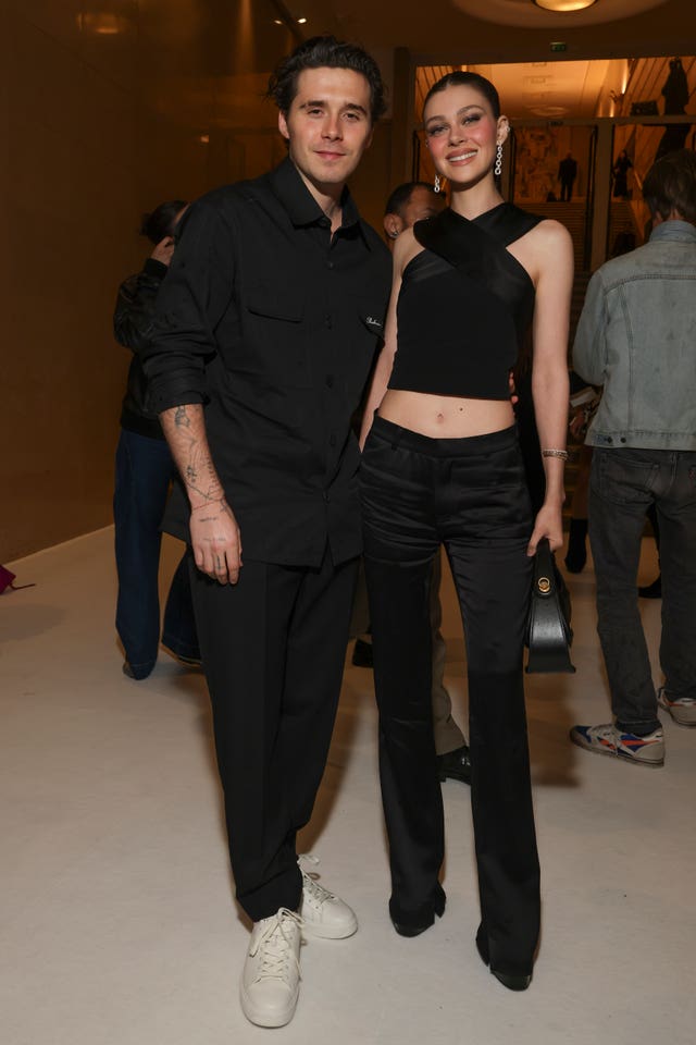 Brooklyn Beckham, left, and Nicola Peltz attend the Balmain Spring/Summer 2025 collection