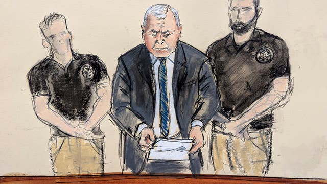 Genaro Garcia Luna stands flanked by US marshals during his sentencing