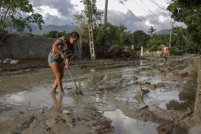 People try to remove mud from a street a week after Hurricane Oscar hit the town of Imias in Guantanamo province