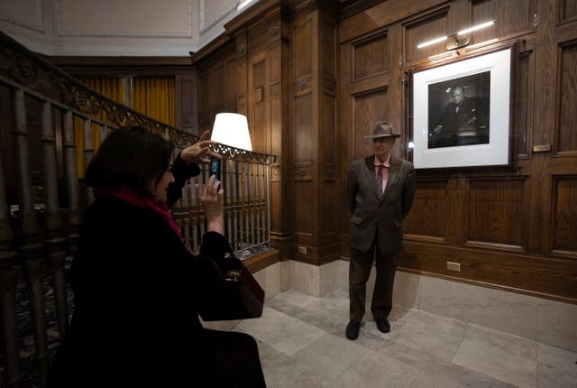 Guests invited to an unveiling ceremony take their photo in front of The Roaring Lion, a 1941 portrait of Winston Churchill taken by Yousuf Karsh, at the Fairmont Chateau Laurier hotel in Ottawa, Ontario