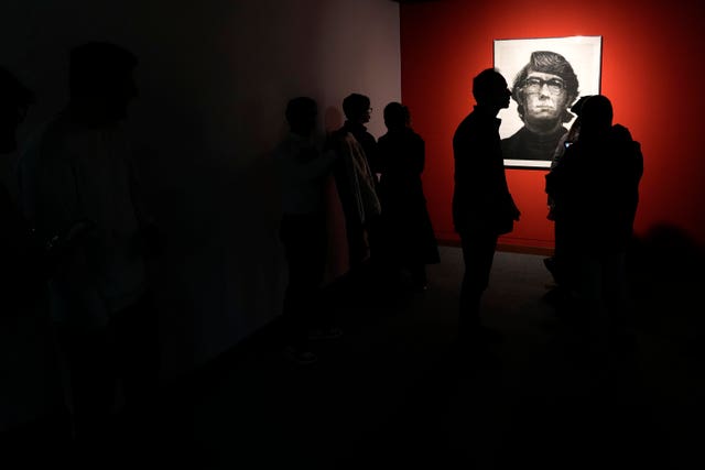 Visitors look at an artwork by American artist Chuck Close