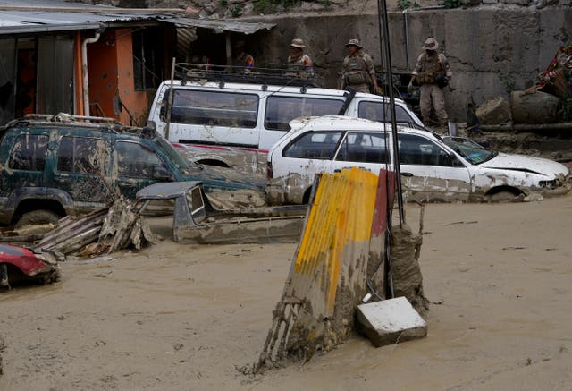 Cars are partially buried in mud in an area affected by a landslide triggered by heavy rains in La Paz, Bolivia