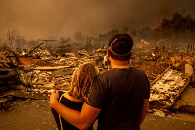 A couple return to their fire-damaged home after the Eaton fire swept through the area in Altadena