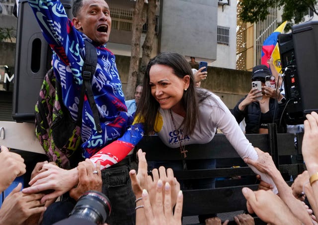 Opposition leader Maria Corina Machado greets supporters during a protest in Caracas, Venezuela