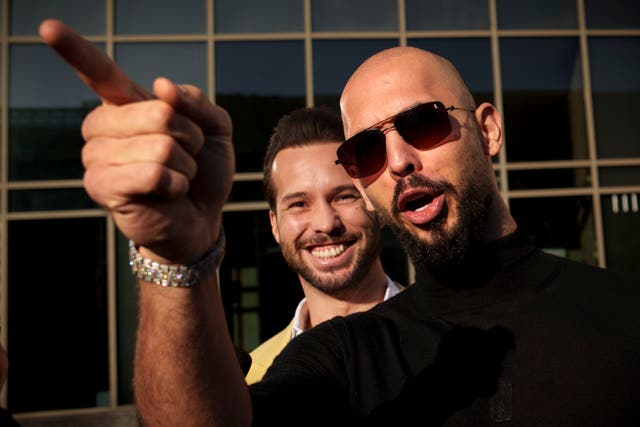 Andrew Tate gestures, next to his brother Tristan