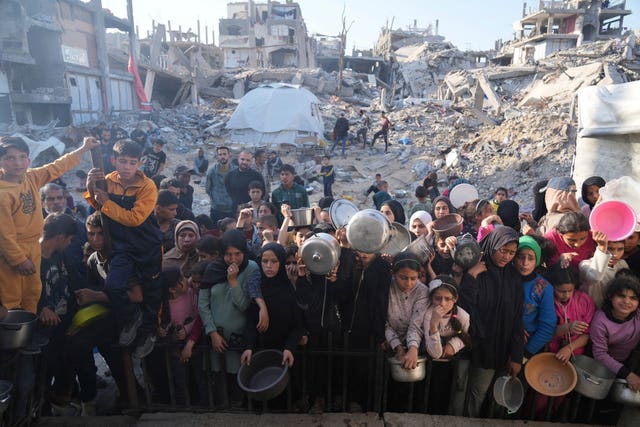 Palestinians wait for donated food