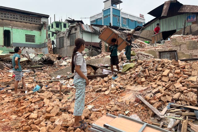 People clear debris from damaged buildings in Naypyitaw