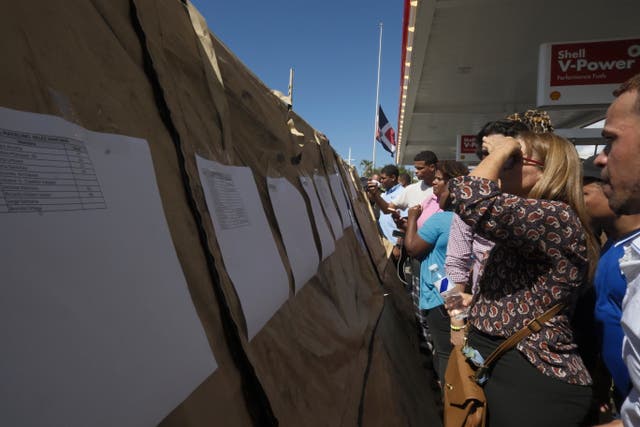 People read lists of survivors outside the Jet Set nightclub in the Dominican Republic