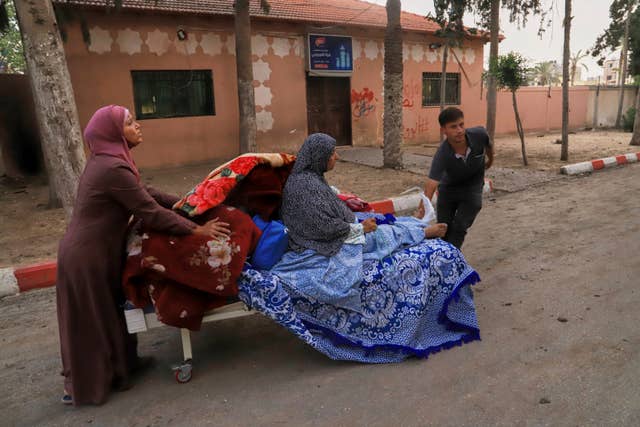 Palestinians evacuate patients from the European hospital in Khan Younis, Gaza, after it was hit by an Israeli army air strike