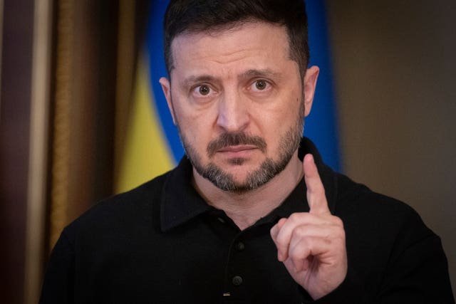 Volodymyr Zelensky pointing up with one hand while speaking