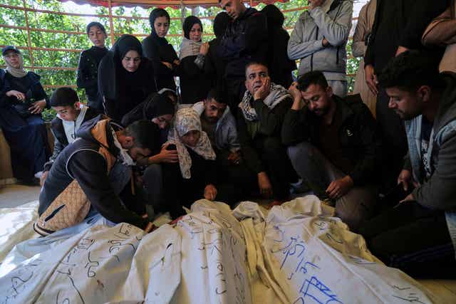 Palestinians mourn over the bodies of their relatives