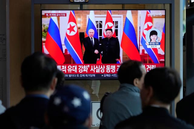 A TV screen shows a file image of North Korean leader Kim Jong Un, right, and Russian President Vladimir Putin in Pyongyang, during a news programme at the Seoul railway station in South Korea