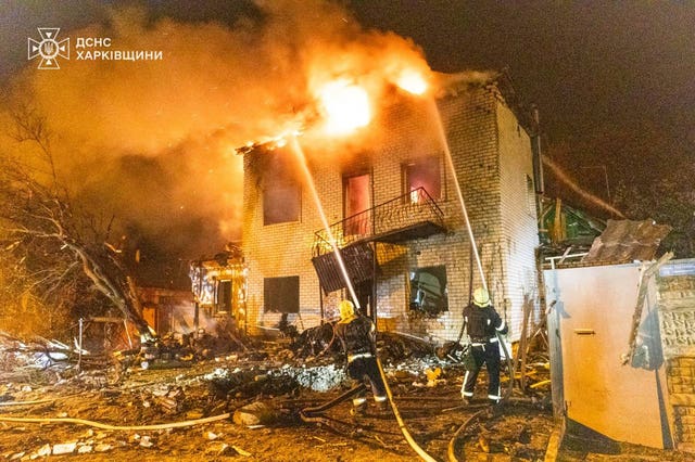 Emergency services personnel work to extinguish a fire following a Russian attack in Kharkiv, Ukraine