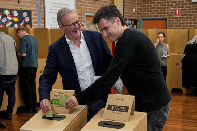 Australian Prime Minister Anthony Albanese and his son Nathan place their votes in a ballot box