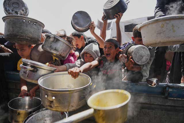 Palestinian children queue for donated food in Khan Younis