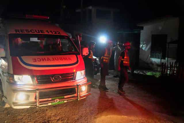 Rescue workers and an ambulance arrive at the site of a suspected Indian missile attack, in Muridke, a town in Pakistan’s Punjab province