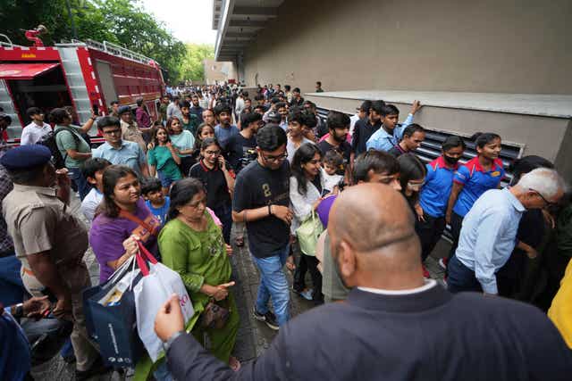 People are escorted to a safe place during a mock security drill at a shopping centre in Ahmedabad, India