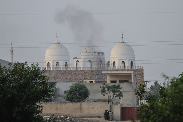 Local residents stand outside a mosque at an Islamic seminary partially damaged by a suspected Indian missile attack on the outskirts of Bahawalpur in Pakistan