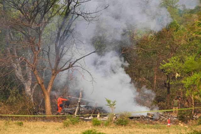 Firefighters douse smoke coming from the debris of an aircraft near Akhnoor on the outskirts of Jammu in India