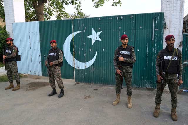Pakistani paramilitary stand guard outside a gate of a complex close to the site of a suspected Indian missile attack, in Muridke