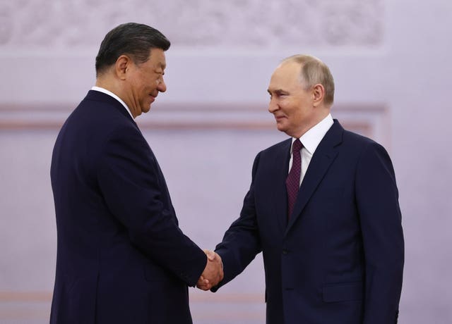 Russian President Vladimir Putin, right, and China's Xi Jinping shake hands during a welcoming ceremony before their talks at the Kremlin in Moscow