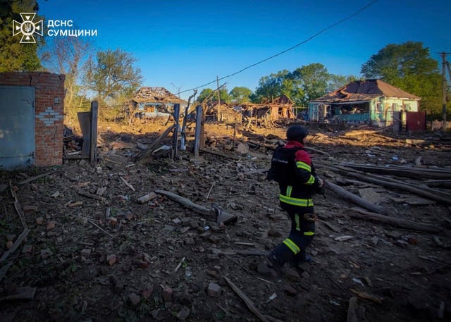 A rescue worker searches residential buildings destroyed by a Russian strike in Sumy, Ukraine