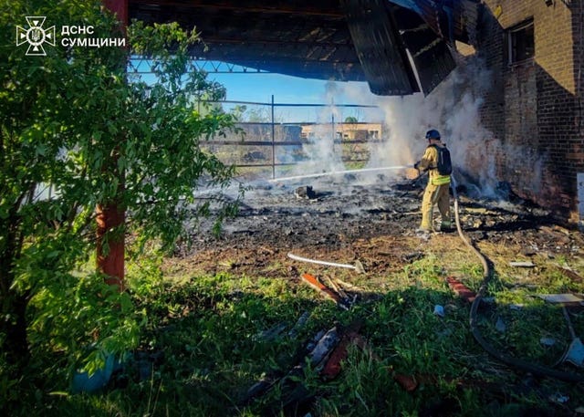 A rescue worker puts out a fire at a building which was heavily damaged by a Russian strike in Sumy, Ukraine