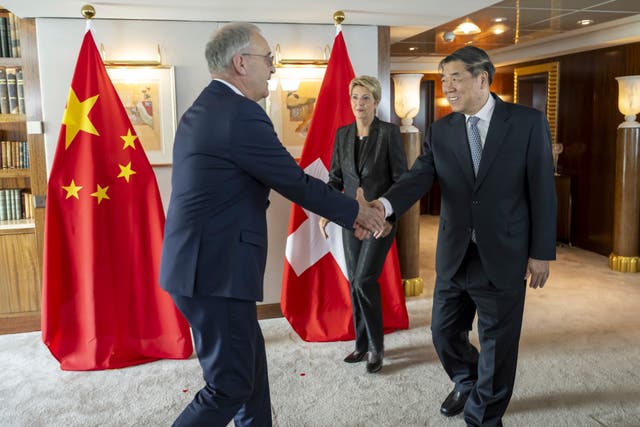 Switzerland’s Economy Minister Federal Councillor Guy Parmelin, left, shakes hands with Chinese Vice Premier He Lifen