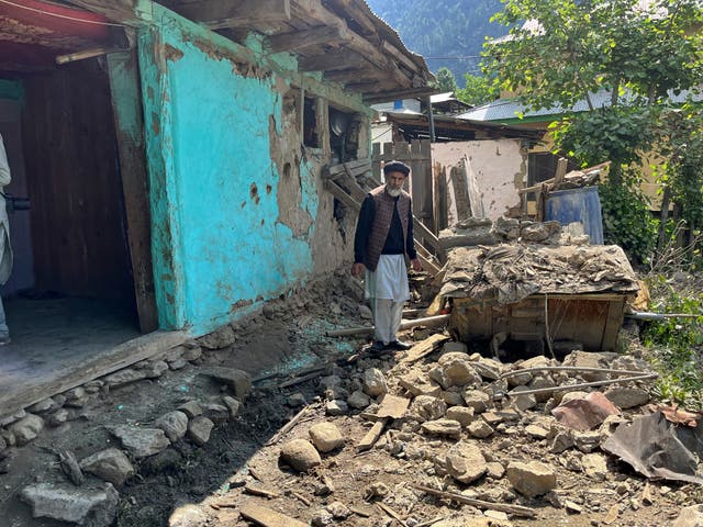 A Kashmiri villager examines damages to his house