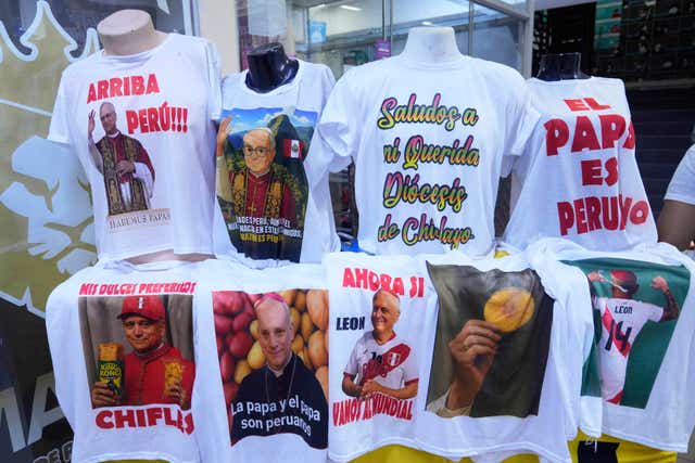 T-shirts featuring images of newly elected Pope Leo XIV and references to his time in Peru are on display for sale in Lima